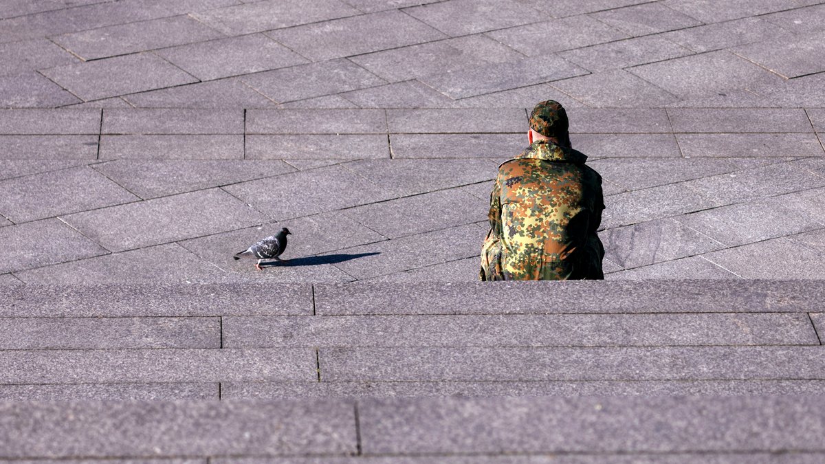 Ein Bundeswehr-Soldat sitzt auf einer Steintreppe (Symbolbild)