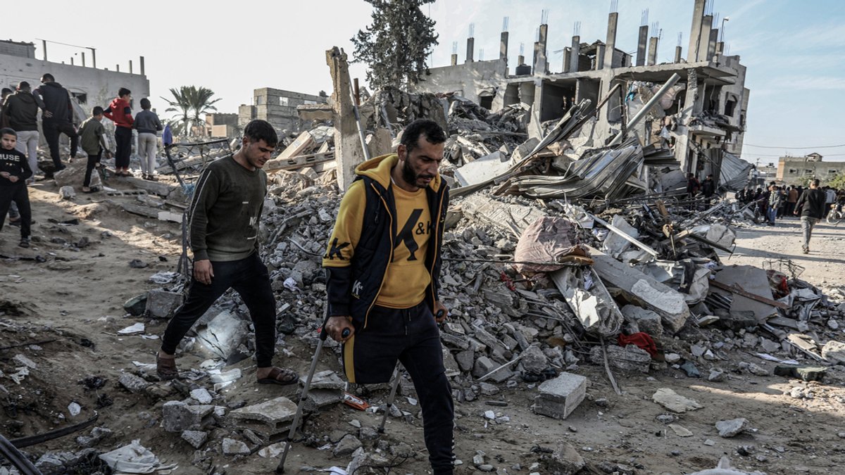 04.12.2023, Palästinensische Gebiete, Rafah: Palästinenser inspizieren nach einem israelischen Luftangriff ein zerstörtes Haus und suchen nach Überlebenden. 