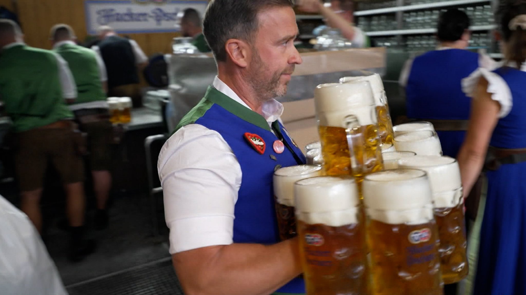 Kellner trägt Maßkrüge durchs Zelt