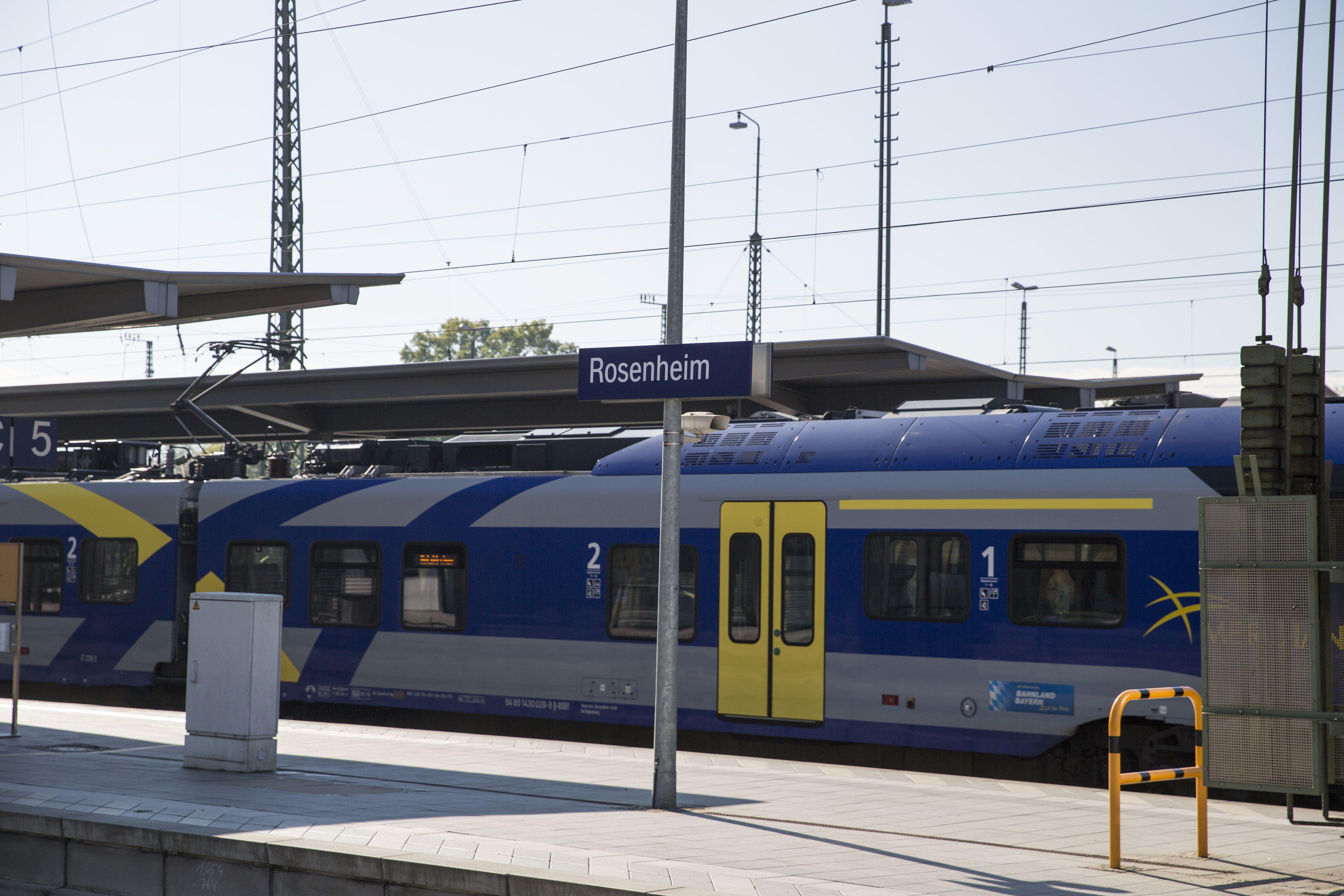 Ein gelb-graublauer Zug der Bayerischen Regiobahn steht im Bahnhof Rosenheim 