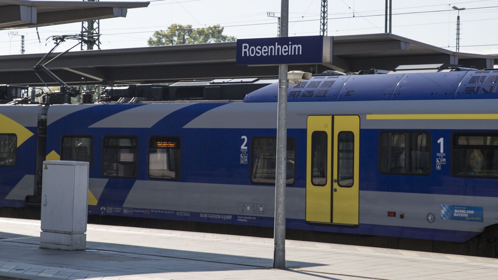 Ein gelb-graublauer Zug der Bayerischen Regiobahn steht im Bahnhof Rosenheim 