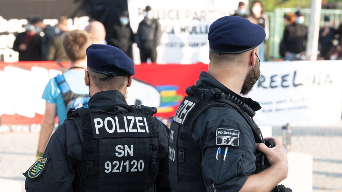 Polizisten stehen vor Beginn eines Prozess gegen eine Frau und drei Männer vor dem Oberlandesgericht (OLG) Dresden vor Demonstranten