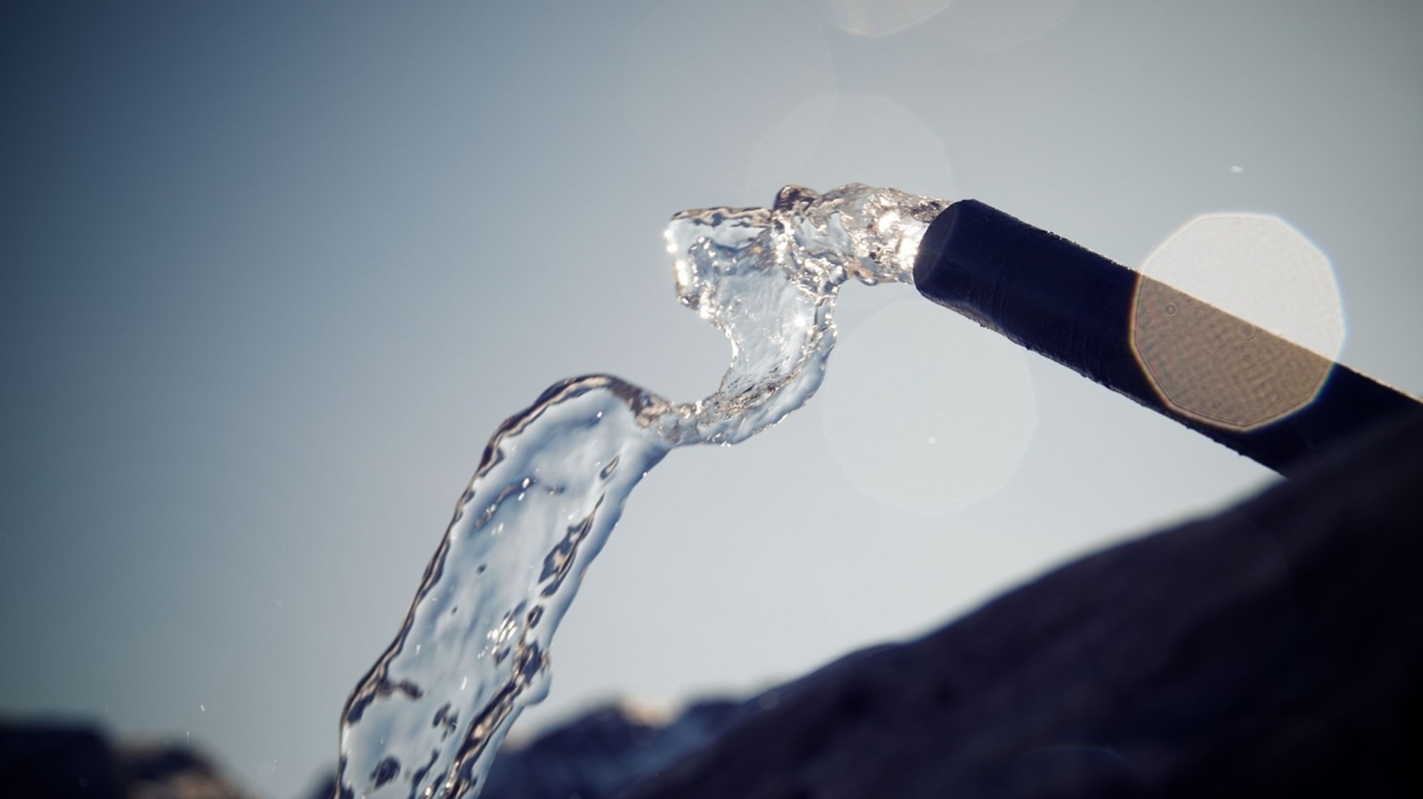 Wasser spritzt aus einem Wasserschlauch 