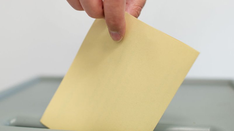Ein Wahlzettel wird in eine Urne eingeworfen | Bild: dpa-Bildfunk/Uwe Anspach Ein Wahlzettel wird in eine Urne eingeworfen