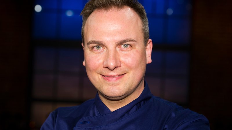 Tim Raue, Sternekoch, schaut in die Kamera und lächelt. | Bild: picture alliance / Sven Simon | Malte Ossowski/SVEN SIMON Tim Raue, Sternekoch, schaut in die Kamera und lächelt.