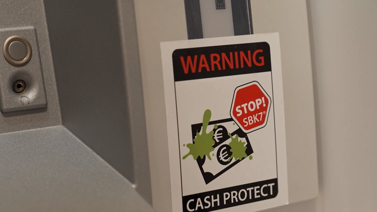 Ein Geldautomat mit Sticker der auf die neue Technologie verweißt, welche Banknoten mit Farbe zerstört, beim Versuch den Geldautomaten zu knacken.