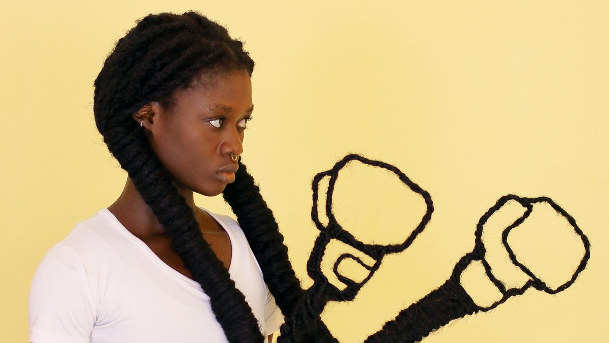 Frau mit langen schwarzen, zu Boxhandschuhen geformten Zöpfen