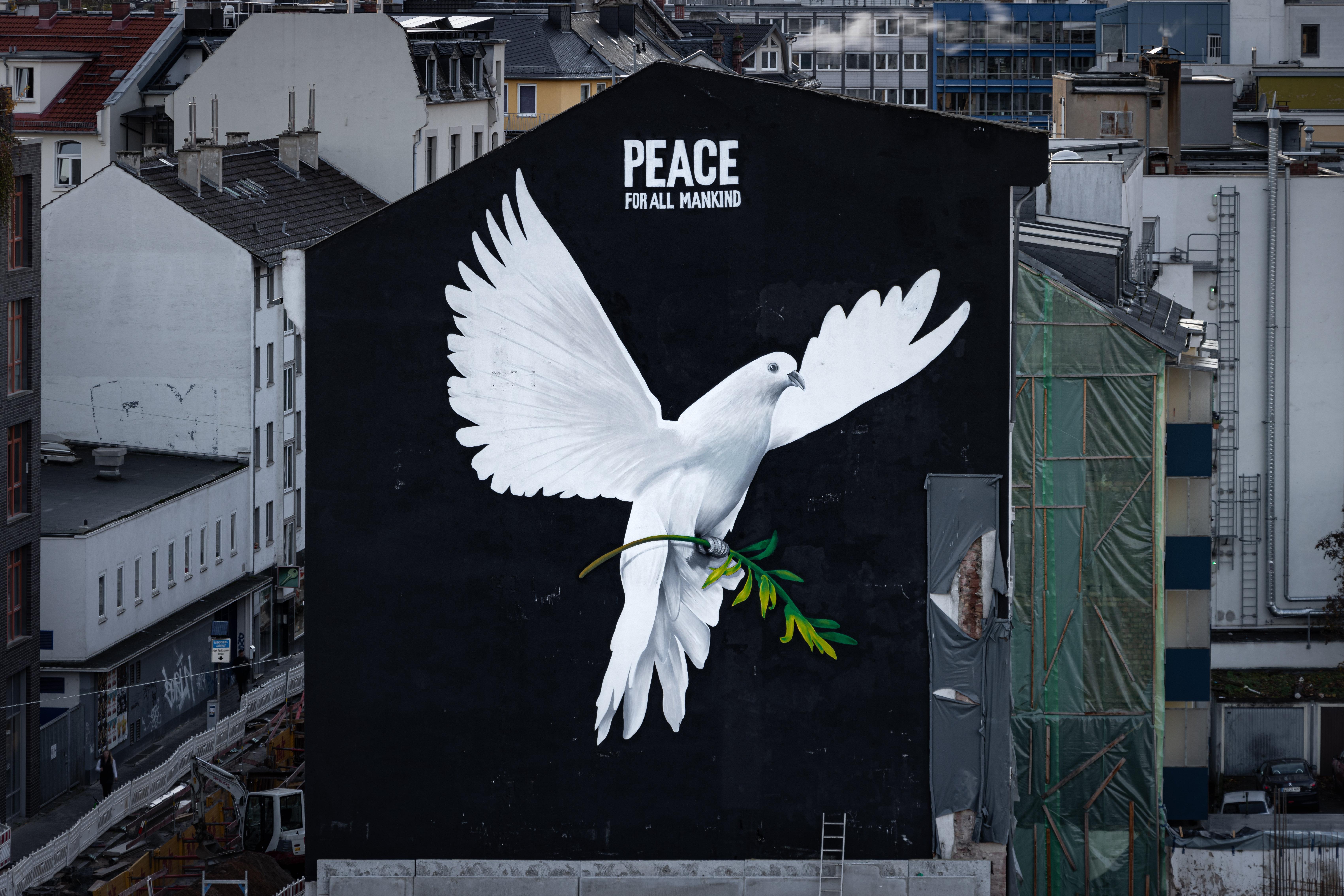 "PEACE FOR ALL MANKIND" (Frieden für die ganze Menschheit) steht über dem Bild einer riesigen Friedenstaube an einer Hauswand in Frankfurt am Main