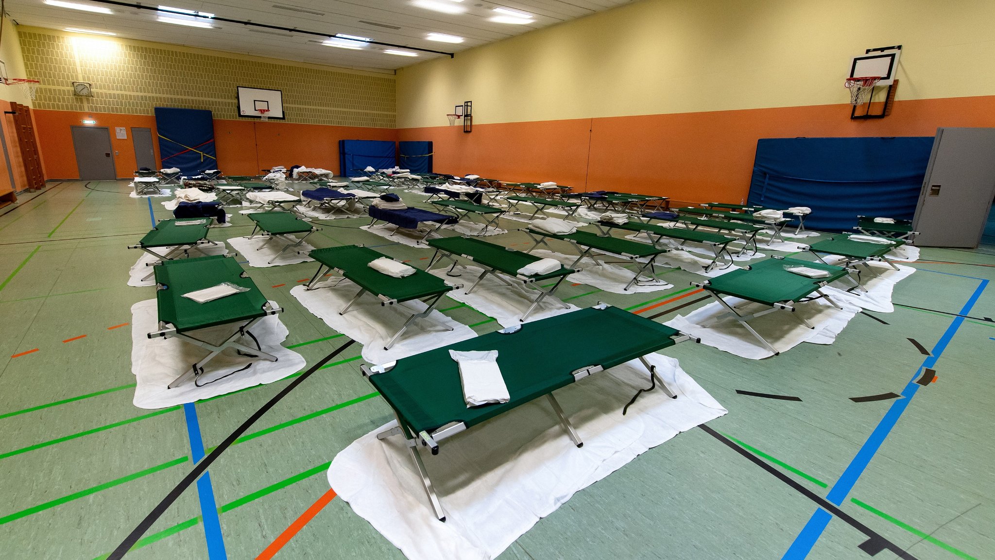 Feldbetten stehen in der Turnhalle von einem Gymnasium in der Nähe des Hauptbahnhofes. Die Stadt München hat in der Schule eine Notunterkunft für Flüchtlinge aus der Ukraine eingerichtet.