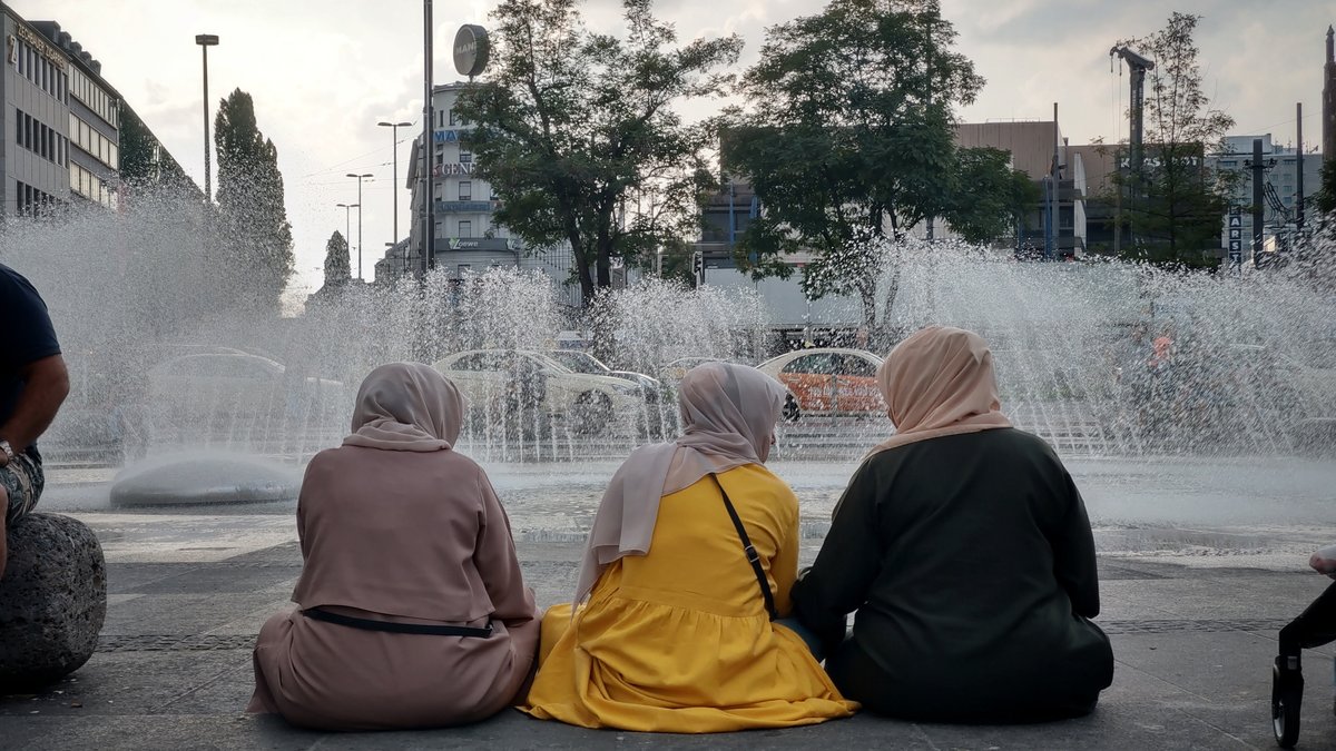 Drei muslimische Frauen sitzen am Stachus in München.