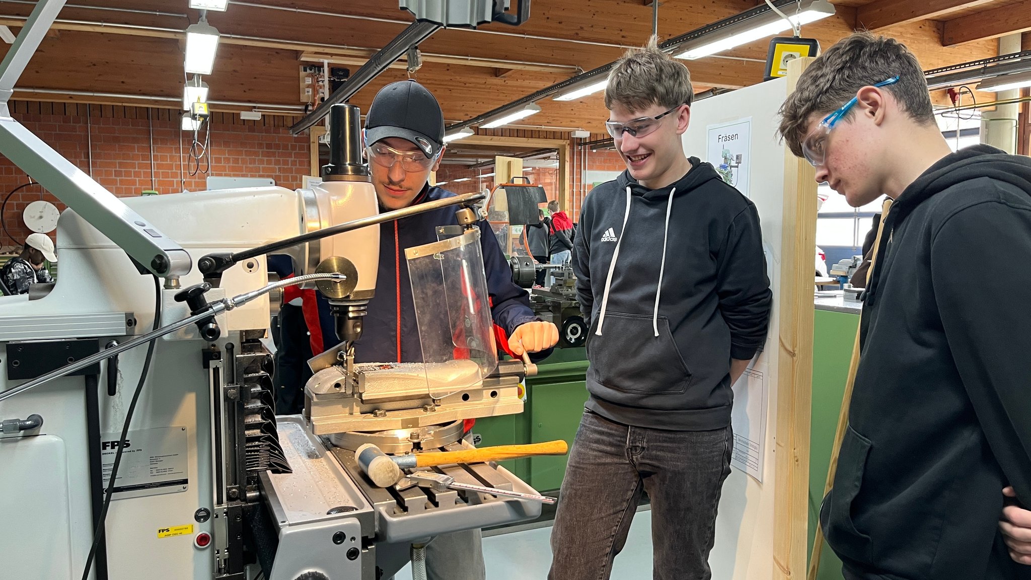 Drei junge Männer beim Tag des Handwerks in Füssen an einer Werkbank