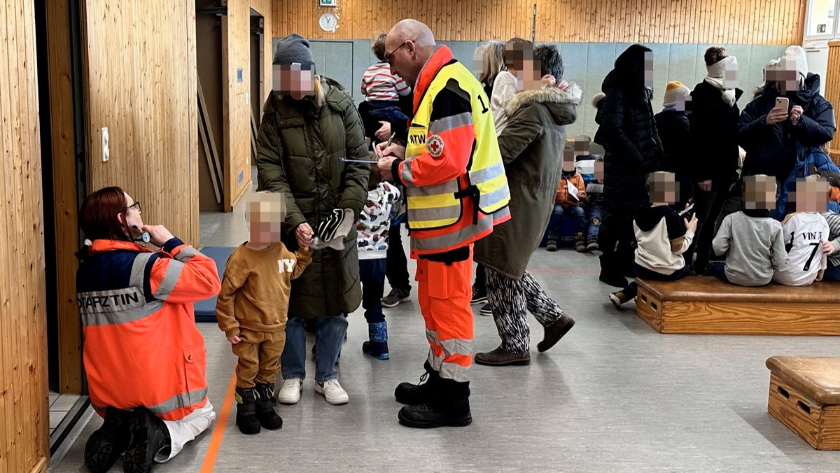Rettungskräfte checken Kindergartenkinder nach dem Kohlenmonoxid-Vorfall im Kindergarten durch.