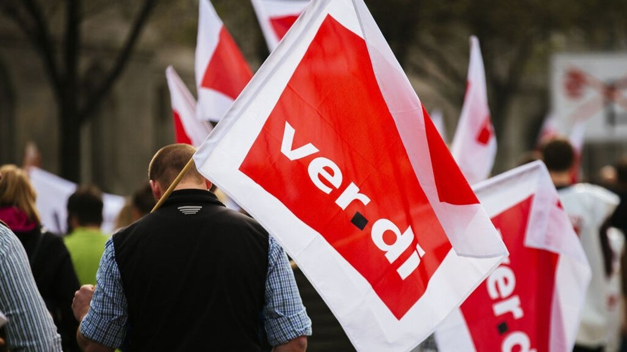 Bei einem Streik sind protestierende Menschen mit Fahnen zu sehen. Auf den Fahnen steht "ver.di"