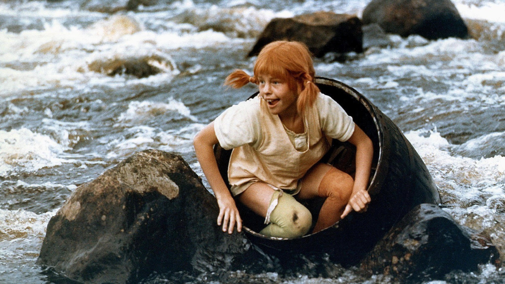 Pippi steigt aus dem Fass, mit dem sie einen wilden Fluss entlanggeschwommen ist. Inger Nilsson im Film 'Mit Pippi Langstrumpf Auf Der Walze' (1979)