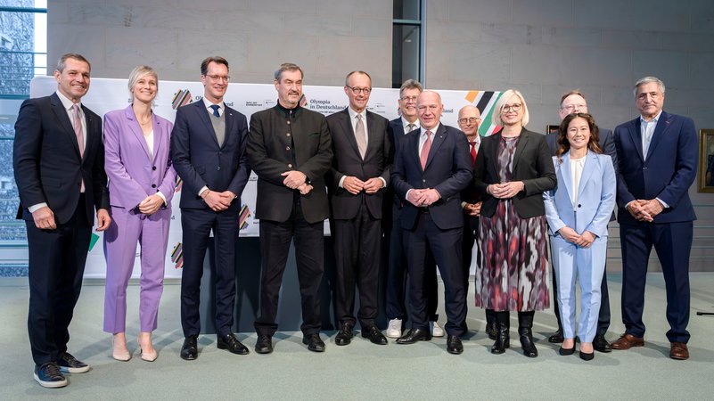 Michael Mronz, Britta Heidemann, Hendrik Wüst, Markus Söder, Friedrich Merz, Kai Wegner, Thomas Weikert, Peter Tschentscher, Christiane Schenderlein, Torsten Burmester, Kim Bui und Kaweh Niroomand bei der Unterzeichnung der Vereinbarung zur Olympiabewerbung im Bundeskanzleramt. | Bild: picture alliance / Geisler-Fotopress | Bernd Elmenthaler/Geisler-Fotopr Michael Mronz, Britta Heidemann, Hendrik Wüst, Markus Söder, Friedrich Merz, Kai Wegner, Thomas Weikert, Peter Tschentscher, Christiane Schenderlein, Torsten Burmester, Kim Bui und Kaweh Niroomand bei der Unterzeichnung der Vereinbarung zur Olympiabewerbung im Bundeskanzleramt.