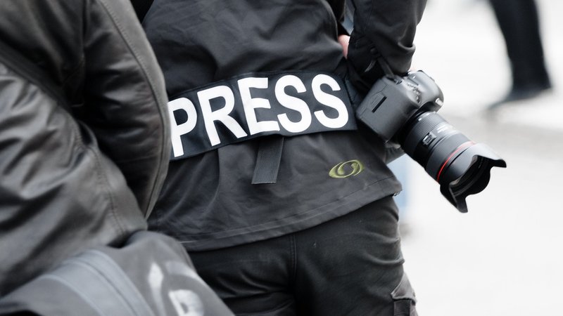 Ein Fotoreporter trägt bei einer Demonstration einen Aufnäher "PRESS", um sich als Journalist zu kennzeichnen.