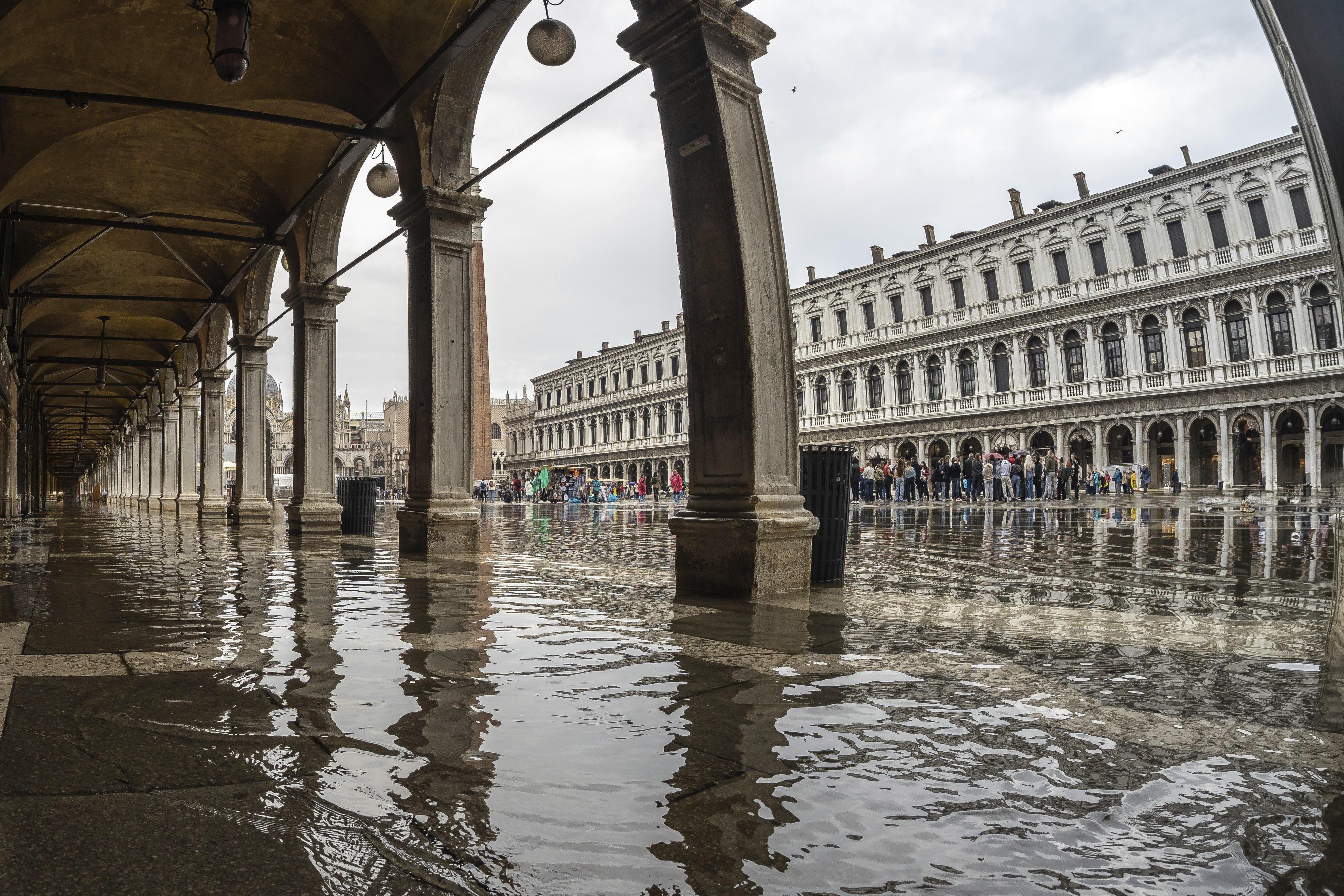 Touristen auf der überschwemmten Piazza San Marco in Venedig.