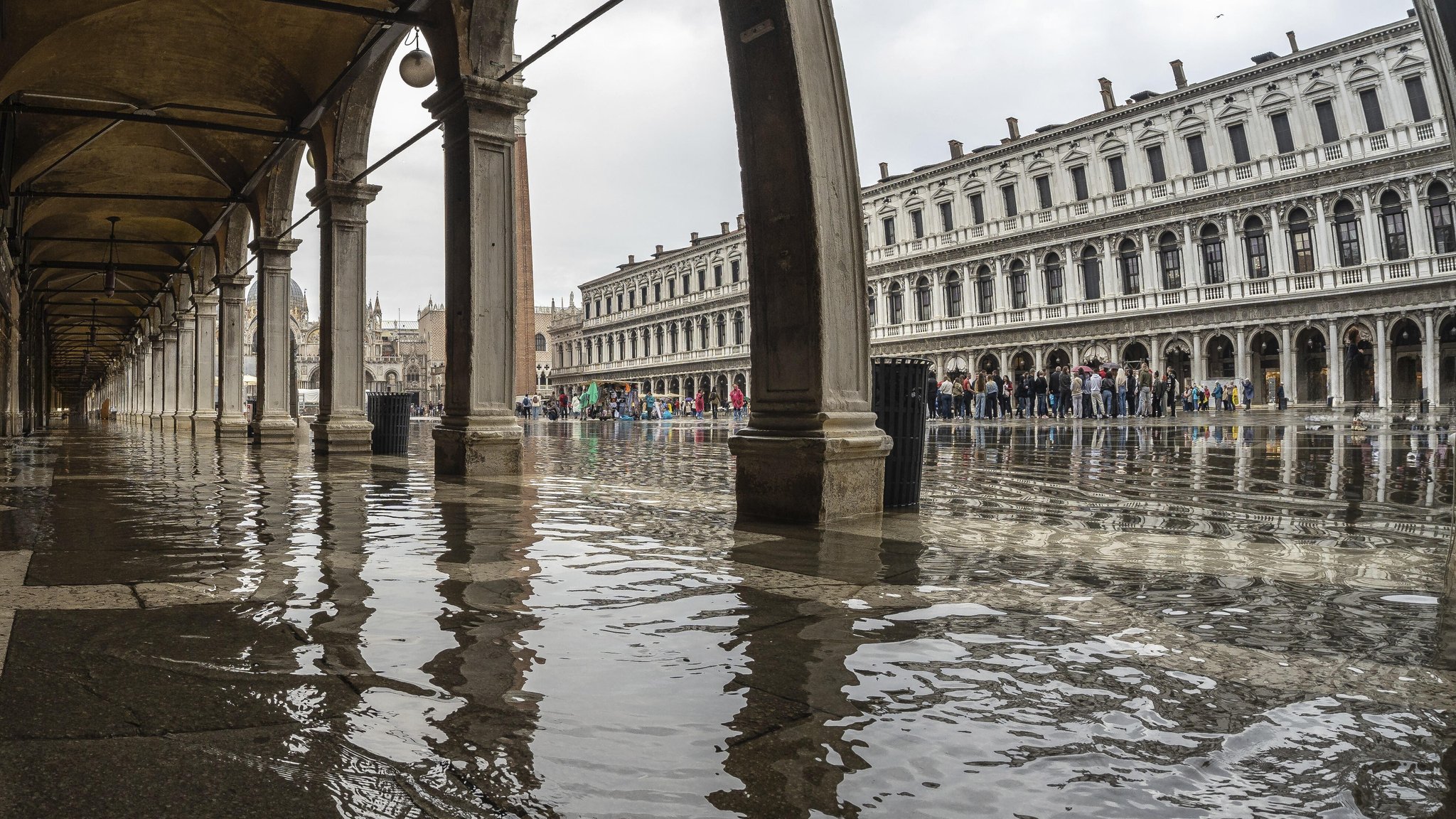 Touristen auf der überschwemmten Piazza San Marco in Venedig.