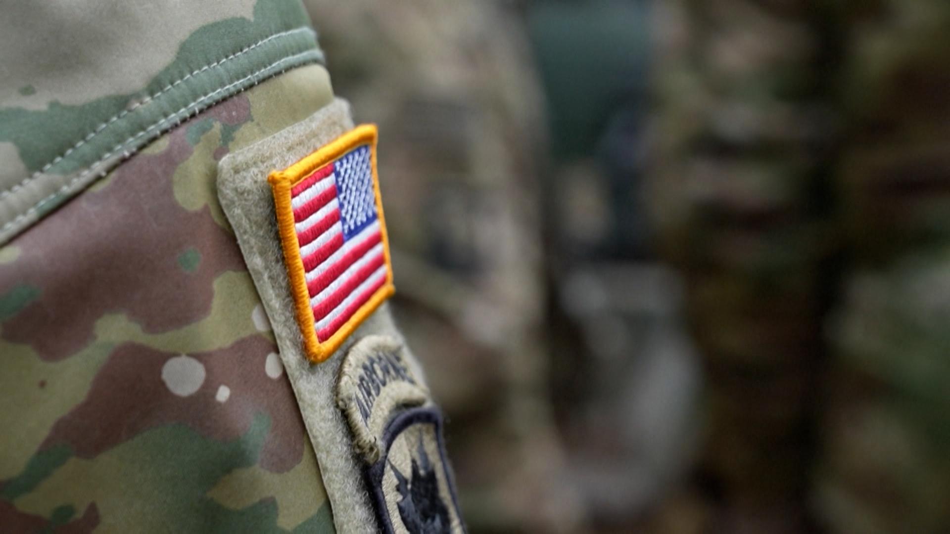 Nahaufnahme der Schulter eines Soldaten in Tarnfleck mit einem US-Flaggen-Patch.
