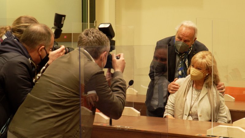 Fotografen machen Fotos von Wiesn-Wirt Günter Steinberg und seiner Ehefrau – beide mit Corona-Schutzmaske – im Gerichtssaal.