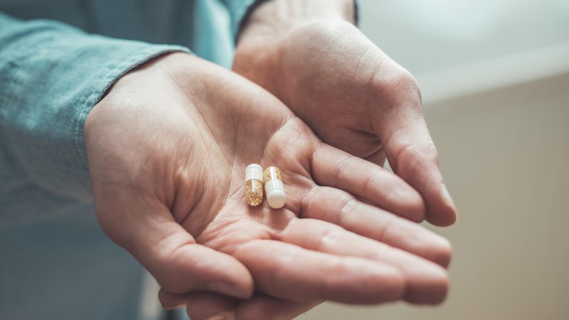 Tabletten liegen in Hand. Könnte bald ein einziges Mittel gegen das Corona-Virus alle Sorgen unnötig machen? 