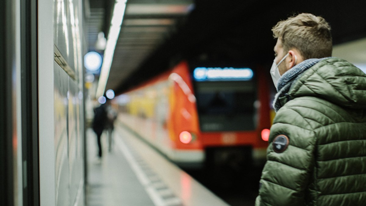 Ein Mann wartet am Bahnsteig auf die S-Bahn.