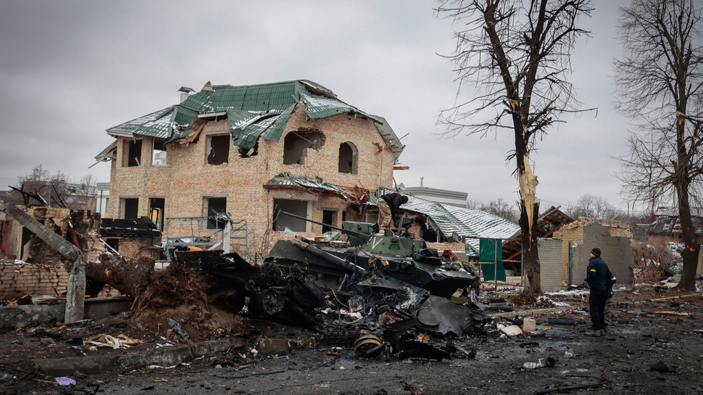 Ukraine, Butscha: Ein Mann betrachtet die ausgebrannten Überreste russischer Militärfahrzeuge. 