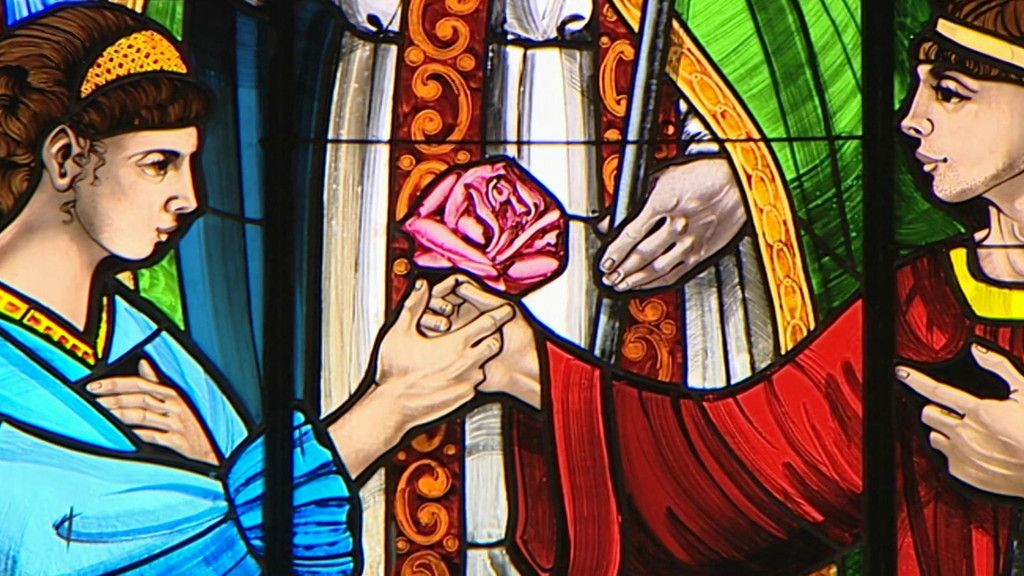 Ein Ehepaar kniet unter dem Heiligen Valentin im Fensterbild in der Basilika in Terni in Umbrien.