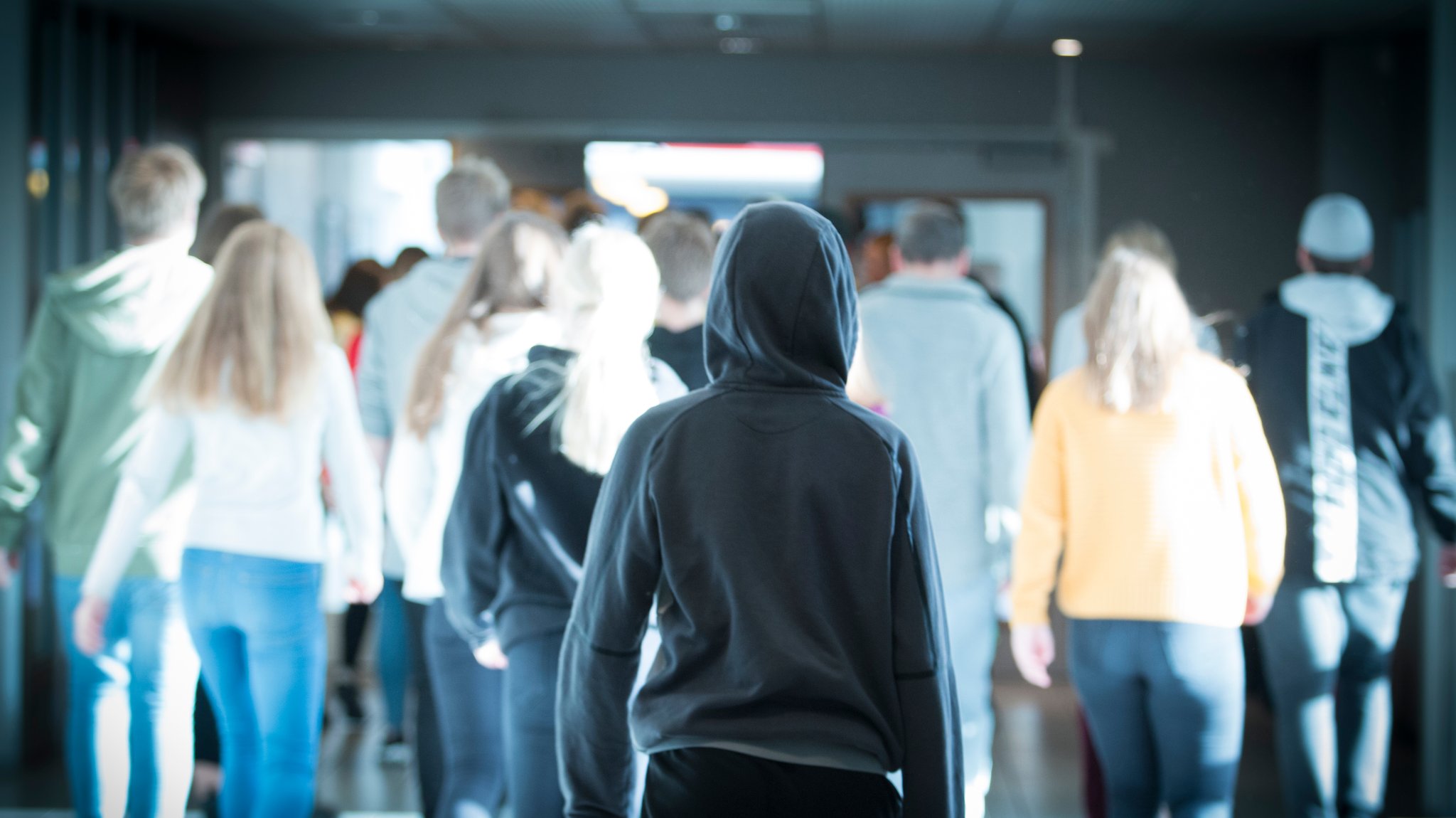 Studierende gehen durch einen Gang in einem Gebäude.