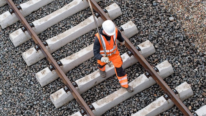 Ein Bahnmitarbeiter läuft über neue Schienen | Bild: dpa-Bildfunk / Lukas Schulze (Symbolbild) Ein Bahnmitarbeiter läuft über neue Schienen