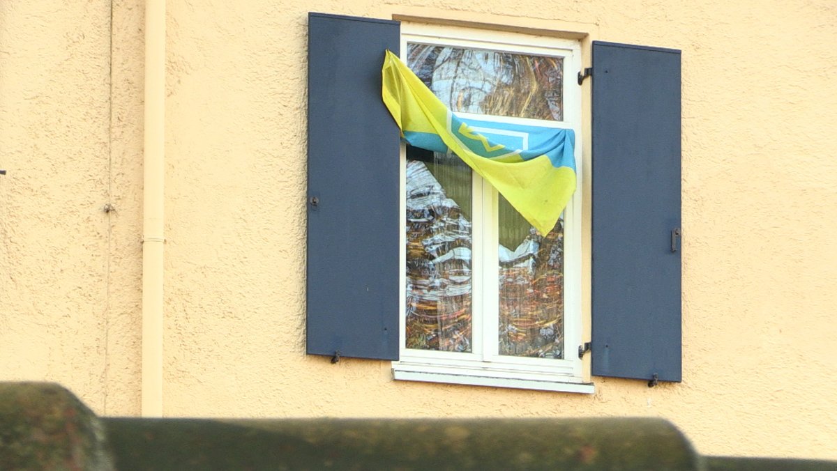 Eine ukrainische Flagge hängt am Fenster eines früheren Kasernengebäudes in Penzing.