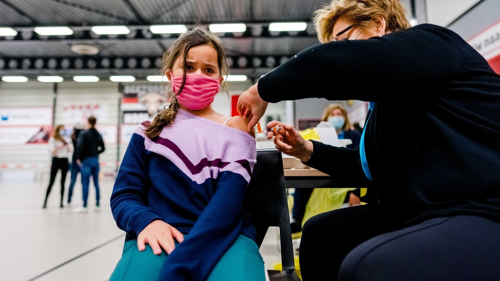 Eine Schülerin wird in der Turnhalle einer Schule geimpft. | Bild: picture alliance / ANP/ MARCO DE SWART Eine Schülerin wird in der Turnhalle einer Schule geimpft.