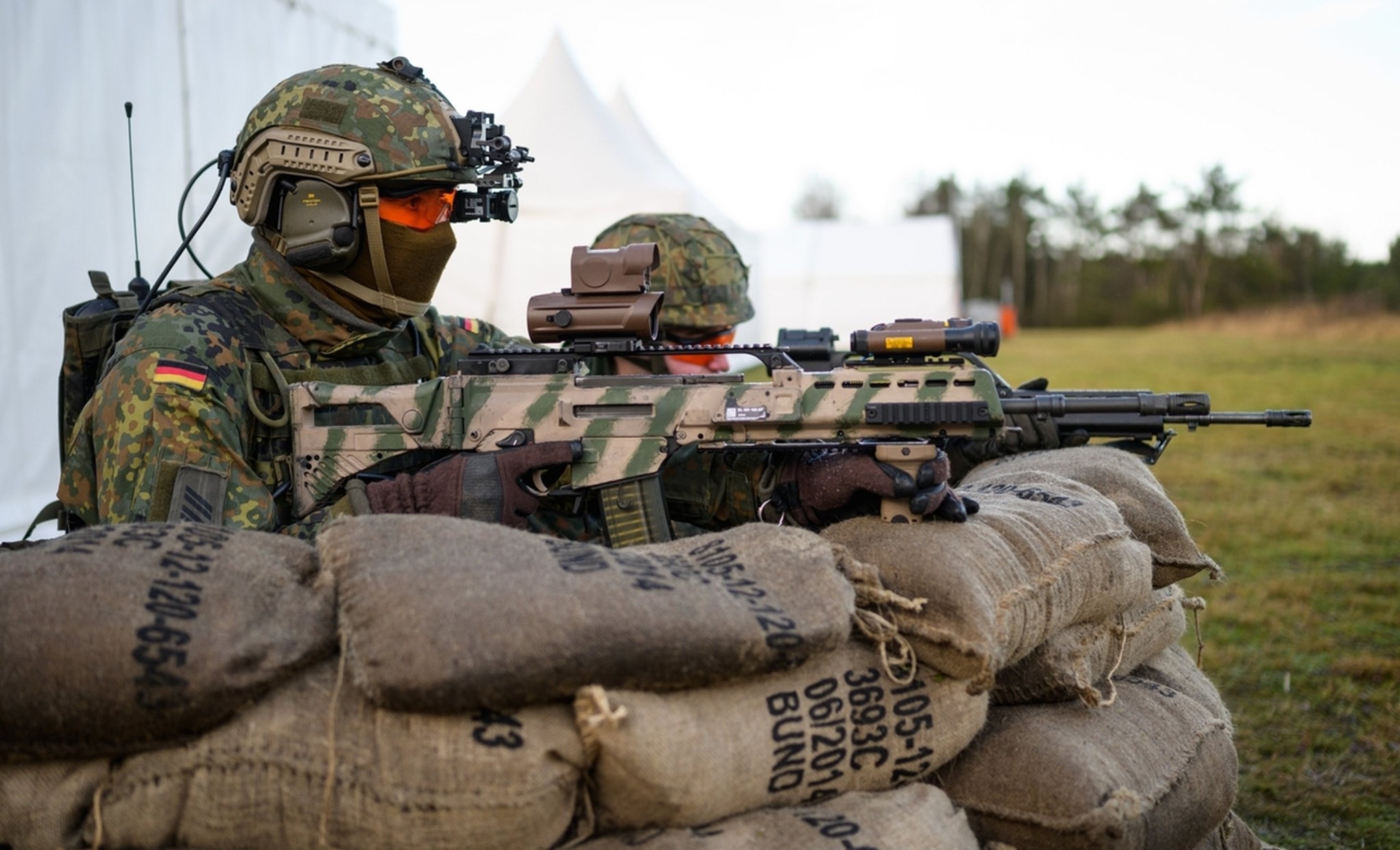 ARCHIV - 07.02.2022, Niedersachsen, Munster: Soldaten der Bundeswehr haben mit dem Sturmgewehr vom Typ G36 A2 während einer Vorführung hinter Sandsäcken Stellung bezogen. 