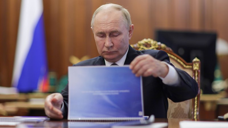 Der russische Präsident blättert durch eine blaue Mappe | Bild: Wjatscheslaw Prokofjew/Picture Alliance Der russische Präsident blättert durch eine blaue Mappe
