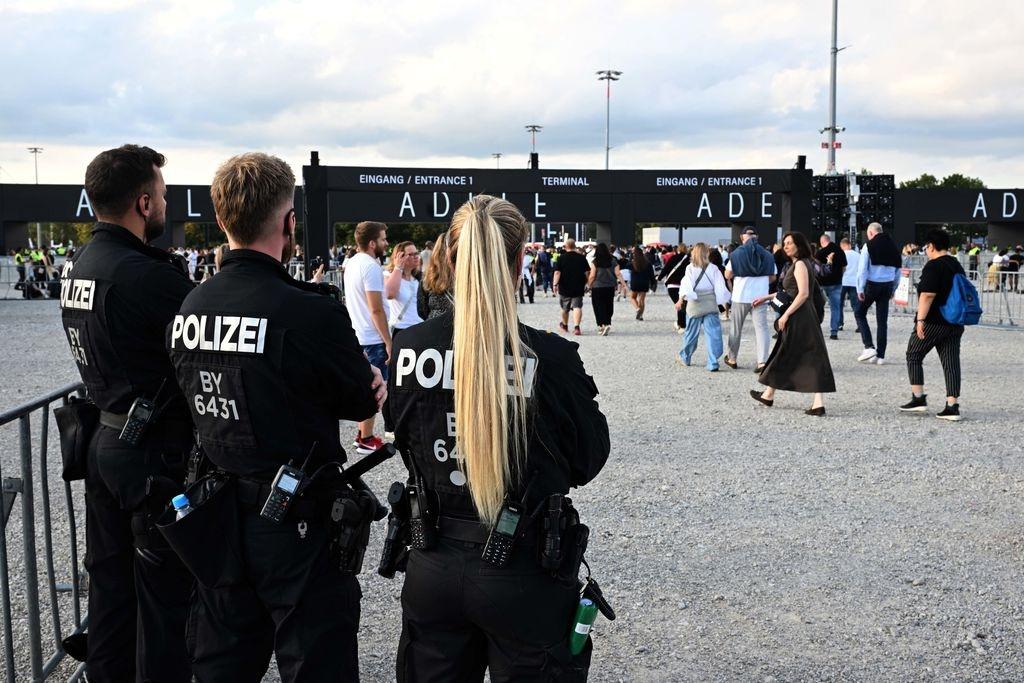 02.08.2024, Bayern, München: Polizisten beobachten Besucher, die auf das Konzert der britischen Sängerin Adele gehen. Foto: Felix Hörhager/dpa +++ dpa-Bildfunk +++