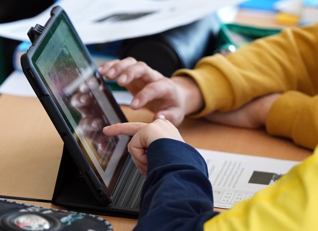 Schüler sitzen während des Unterrichts an einem Tablet. 