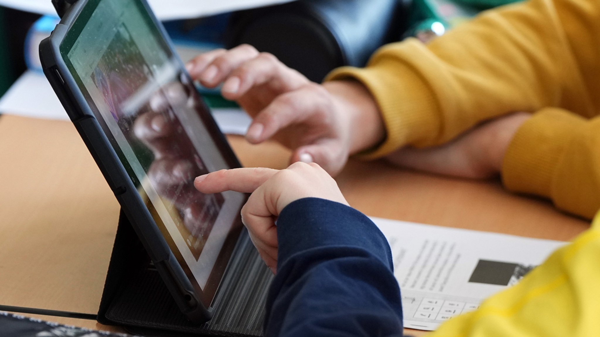 Schüler sitzen während des Unterrichts an einem Tablet. 