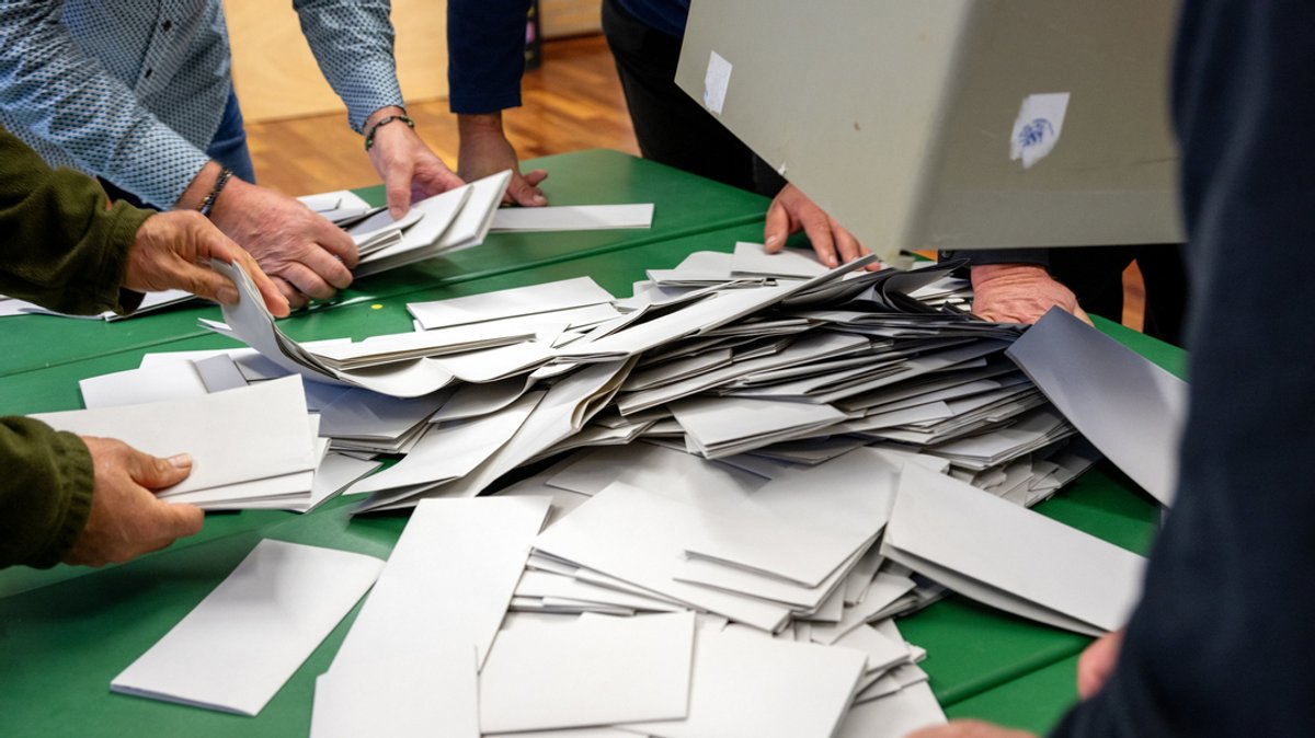 08.10.2023, Bayern, Untermerzbach: Eine Wahlurne wird ausgeleert, die Auszählung der Stimmzettel beginnt.