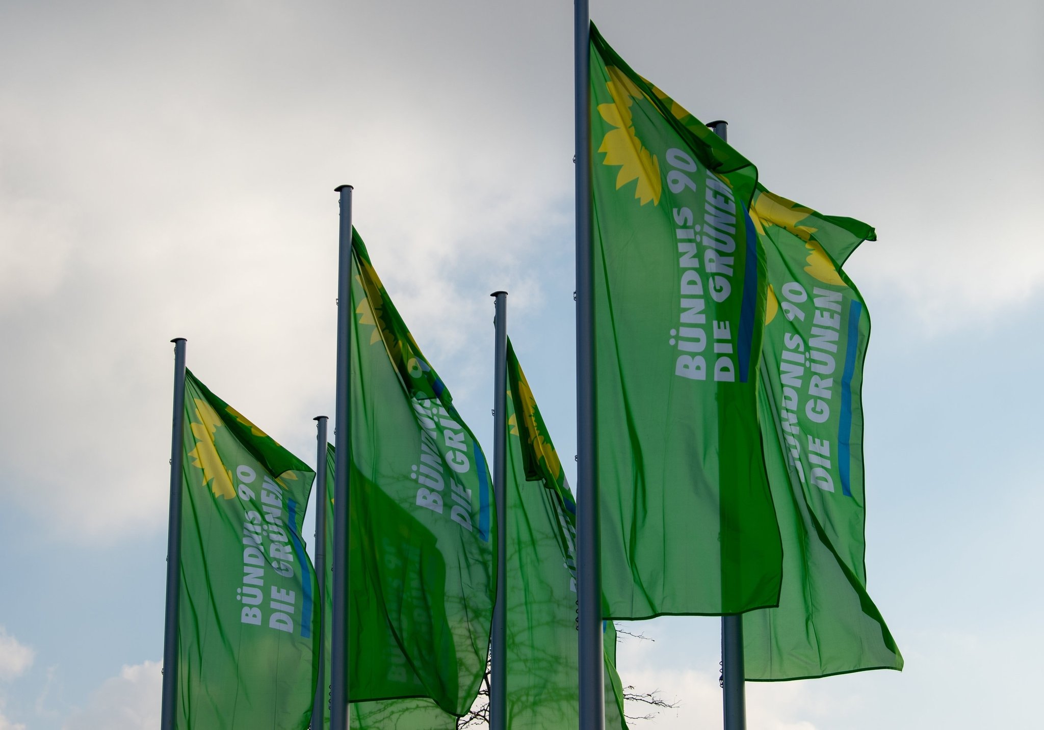 ARCHIV - 06.11.2021, Bayern, Augsburg: Fahnen von Bündnis 90/Die Grünen wehen bei einer Landesdelegiertenkonferenz der bayerischen Grünen vor dem Messezentrum. Bei den bayerischen Grünen gibt es auf einem Landesparteitag am Wochenende gleich zwei Kampfabstimmungen um die Vorsitzenden-Posten. (zu dpa: «Grüne wählen Landesvorstand neu - Mindestens fünf wollen Chef werden») Foto: Stefan Puchner/dpa +++ dpa-Bildfunk +++