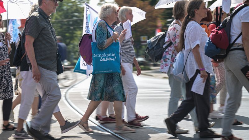 (Symbolbild) Eine Demo-Teilnehmerin trägt einen Beutel mit der Aufschrift "Demokratie leben. | Bild: picture alliance/dpa | Hannes P Albert (Symbolbild) Eine Demo-Teilnehmerin trägt einen Beutel mit der Aufschrift "Demokratie leben.
