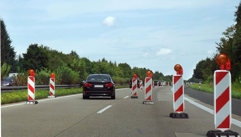 Wegen einer Baustelle auf einer Autobahn wird der Verkehr mithilfe von Baken einspurig.