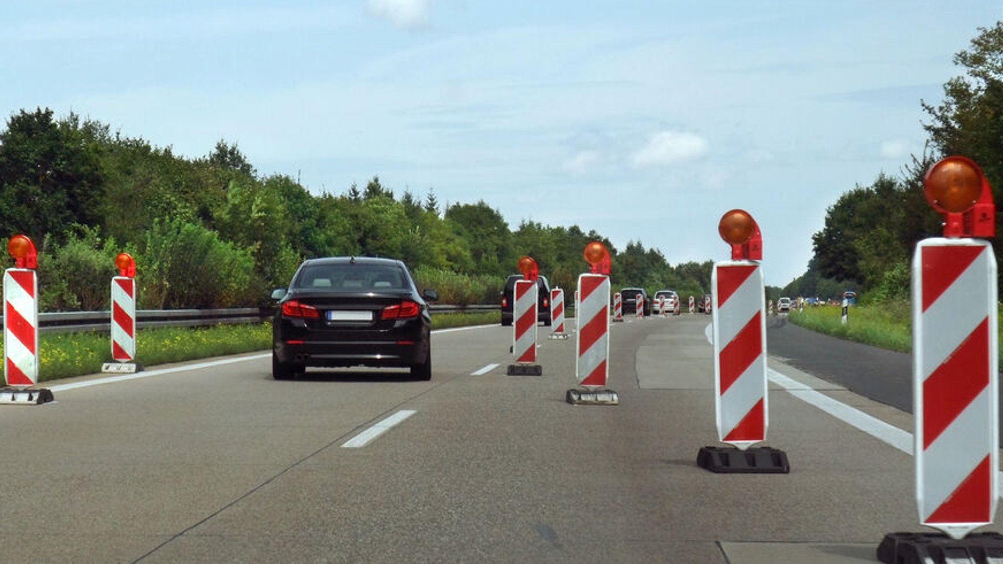 Wegen einer Baustelle auf einer Autobahn wird der Verkehr mithilfe von Baken einspurig.