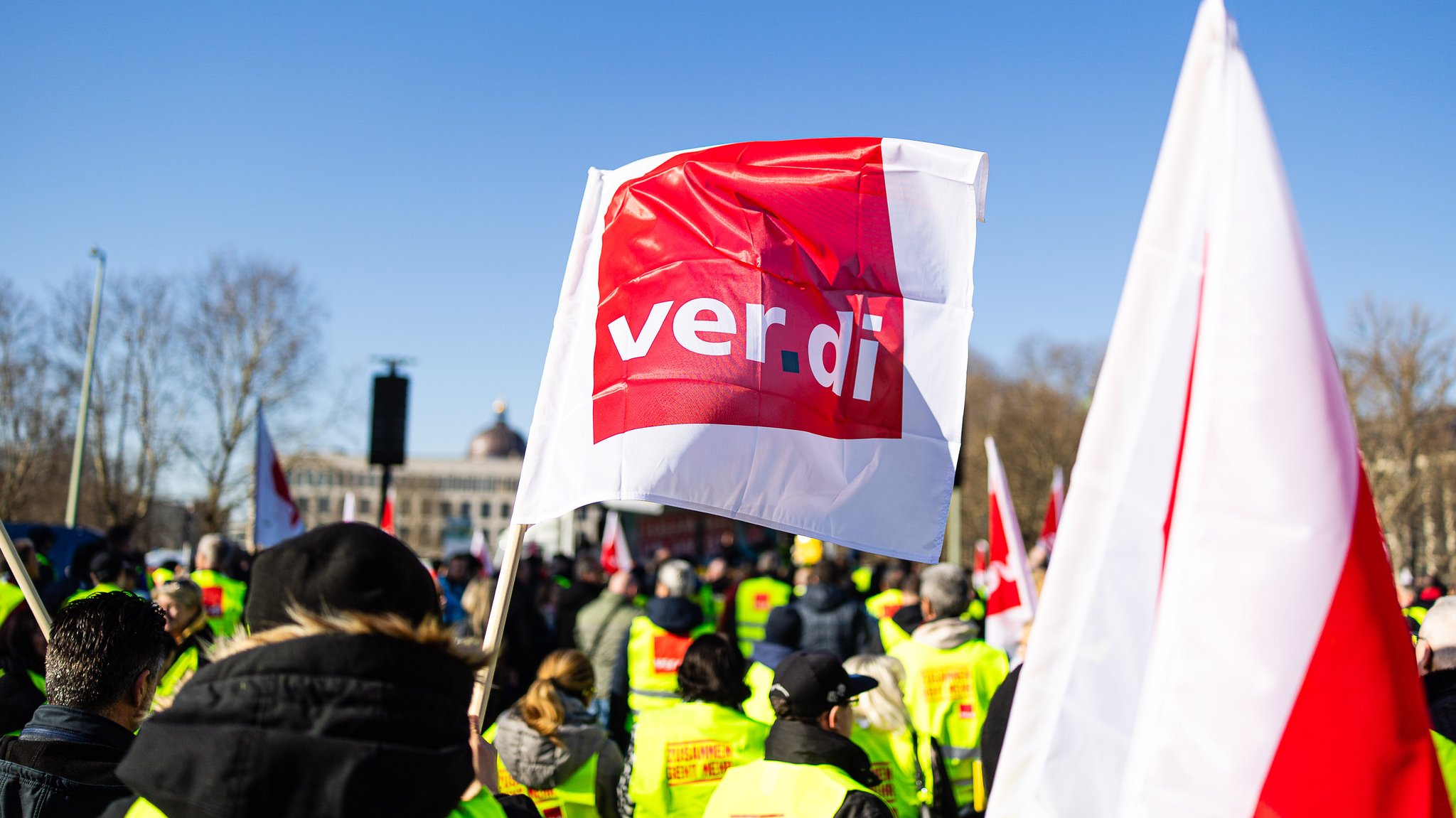 Verdi Flagge und Demonstrierende.