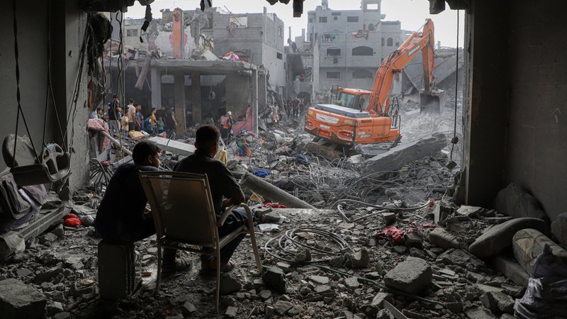 Ein Bagger arbeitet an zerstörten Gebäuden nach israelischen Luftangriffen im Gazastreifen.