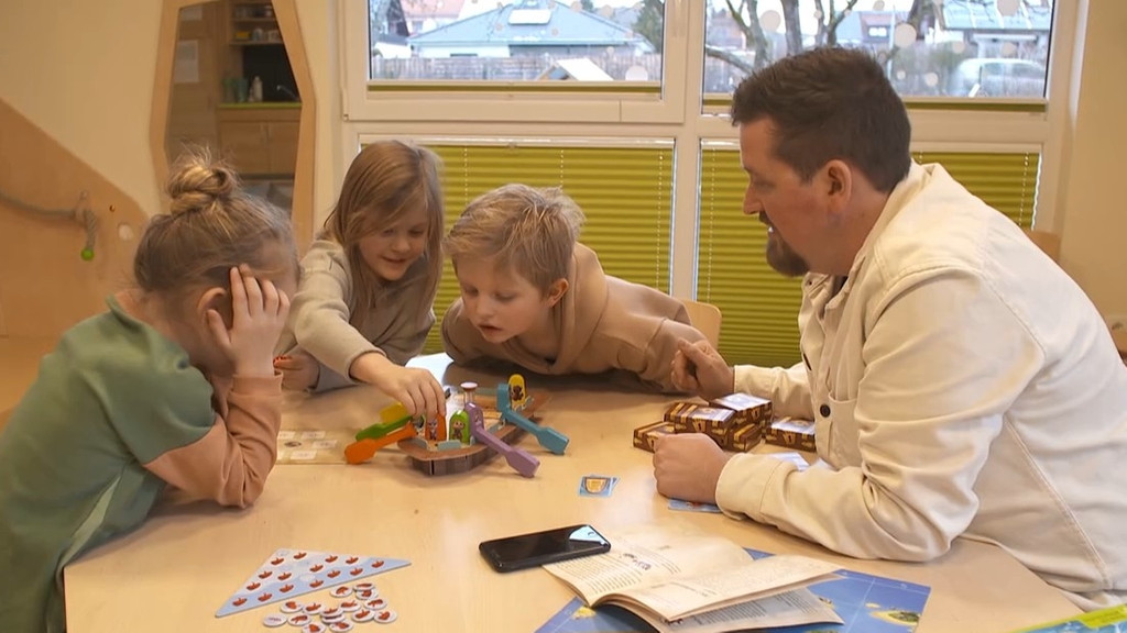 Kindergarten-Kinder testen zusammen mit einem Spieleredakteur ein neues Brettspiel.