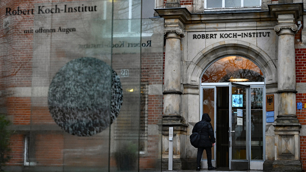 Ein Mensch geht durch den Eingang des Robert Koch-Instituts (RKI).