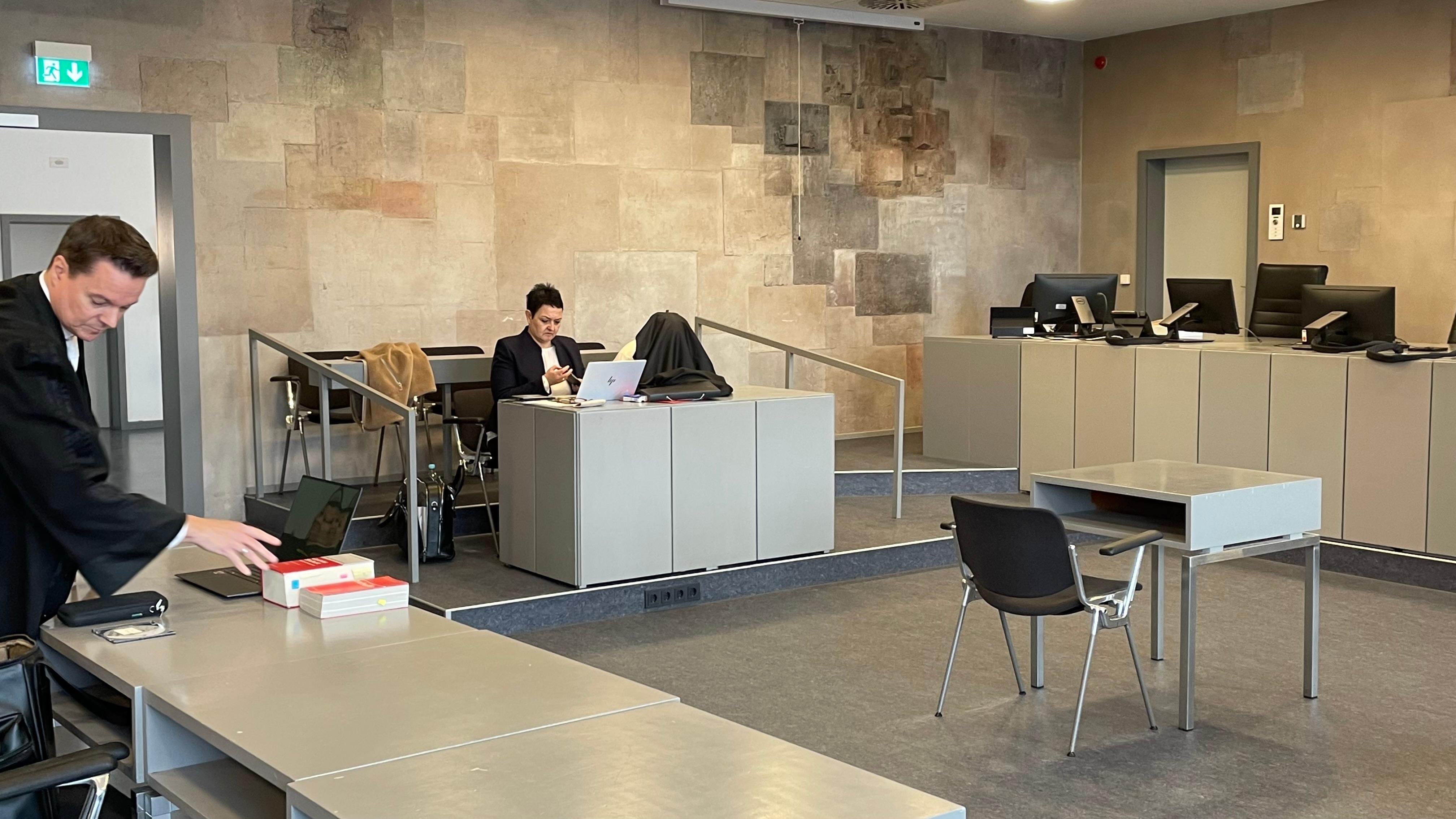 Die Angeklagte mit einer Jacke über dem Kopf zusammen mit ihrer Verteidigerin im Gerichtssaal.