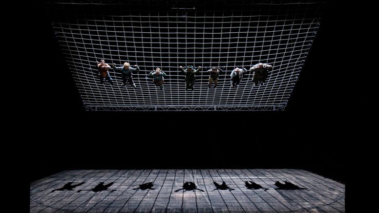 Sieben Menschen in einem großen Netz, am Boden ihr Schatten | Bild:Florian Lösche