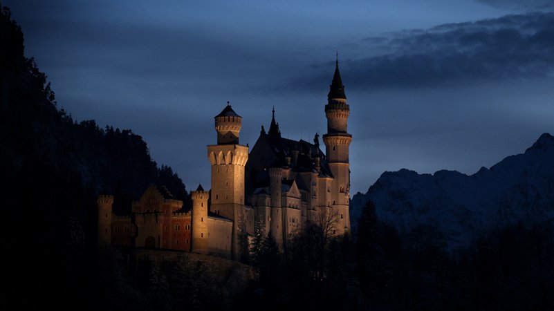 Bayern, Schwangau: Das Schloss Neuschwanstein steht nach Sonnenuntergang zur Blauen Stunde vor dem Panorama der Alpen. | Bild: dpa-Bildfunk/Karl-Josef Hildenbrand Bayern, Schwangau: Das Schloss Neuschwanstein steht nach Sonnenuntergang zur Blauen Stunde vor dem Panorama der Alpen.