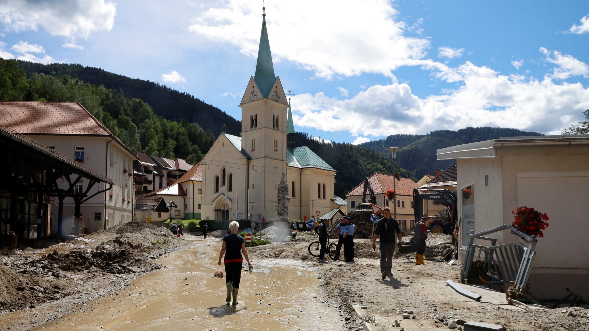 Menschen räumen um eine überflutete Straße herum auf